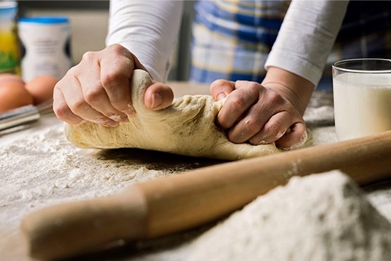 Close up of person kneading dough